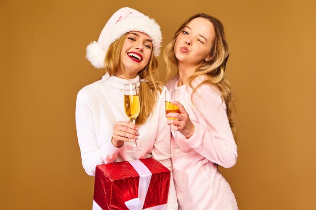 Modelle mit großer Geschenkbox, die Champagner in Gläsern trinken, die Neujahr feiern