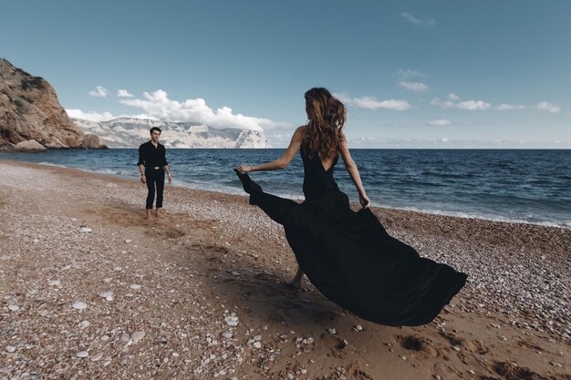Modepaar im schwarzen Kleid und im Anzug im Freien