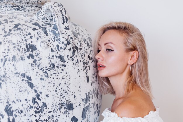 Modeporträt der jungen europäischen Frau mit den blonden Haaren im weißen langen Sommerkleid