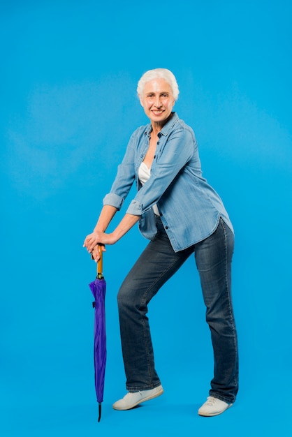 Moderne ältere Frau mit Regenschirm