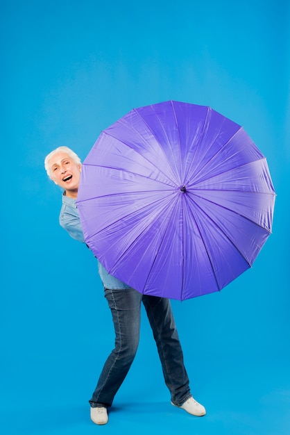 Moderne ältere Frau mit Regenschirm