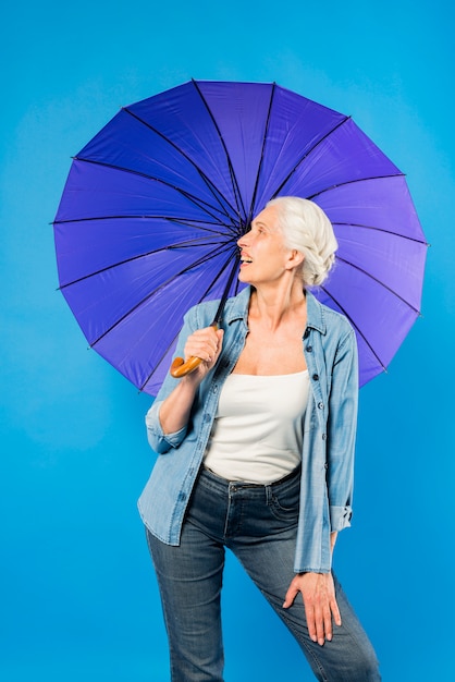 Moderne ältere Frau mit Regenschirm