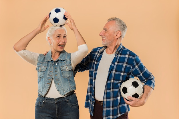 Moderne ältere Paare mit Fußball