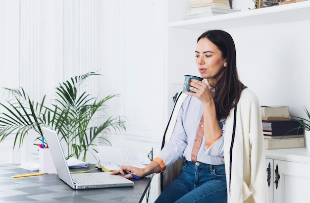 Moderne Frau, die Laptop verwendet