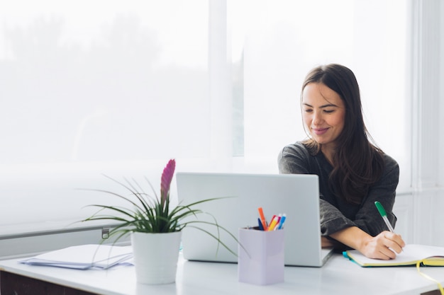 Moderne Frau, die Laptop verwendet