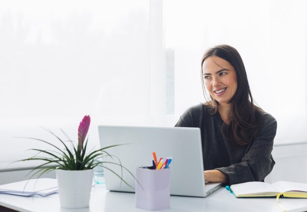 Moderne Frau, die Laptop verwendet