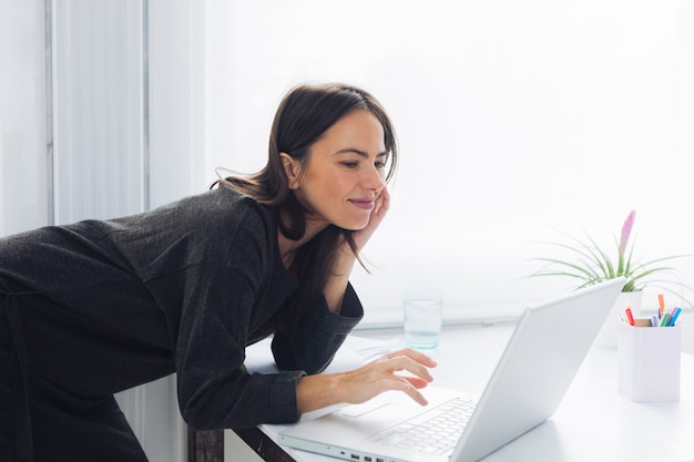 Moderne Frau, die Laptop verwendet