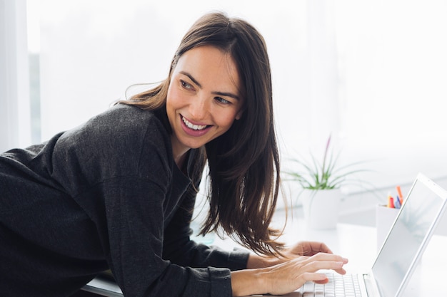 Moderne Frau, die Laptop verwendet