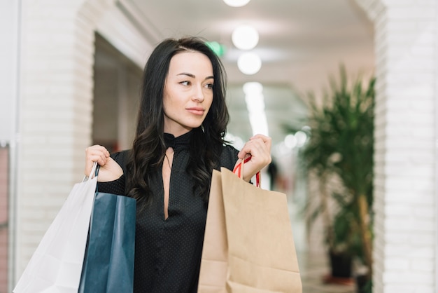 Moderne Frau mit Taschen im Speicher