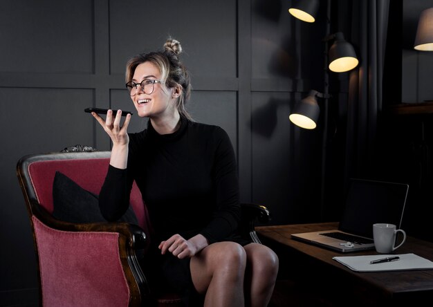 Moderne Geschäftsfrau, die am Telefon im Büro spricht