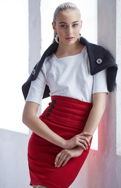 Moderne junge Frau in weißer Bluse und rotem Rock.