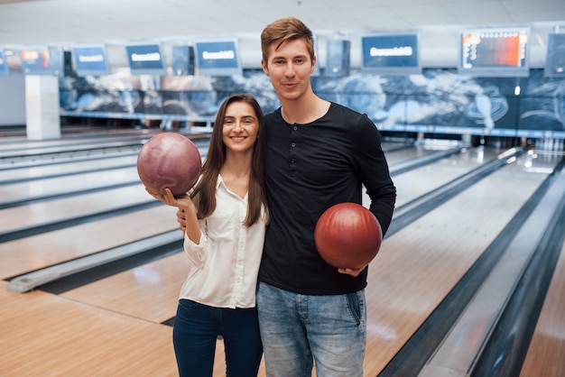 Moderne Menschen. Junge fröhliche Freunde haben an ihren Wochenenden Spaß im Bowlingclub