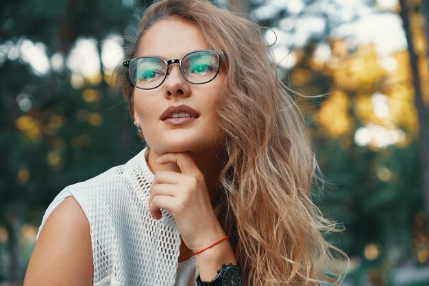 Moderne Modellfrau, die Brillen, ausdrucksstarke Lippen trägt