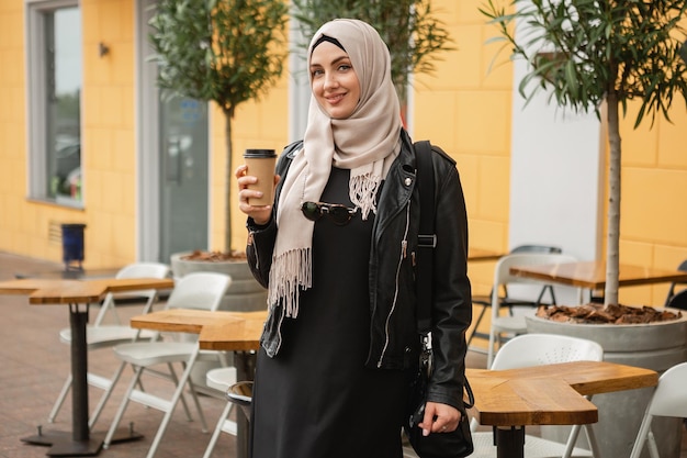 Moderne stilvolle muslimische frau im hijab in der stadtstraße