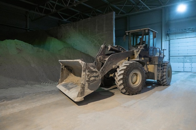 Moderne Technik Der Traktor bewegt Kies Technologische Arbeiten zur Herstellung von Zement Arbeitsatmosphäre mit Kopierraum Haufenweise Sand- und Bodenrohstoffe