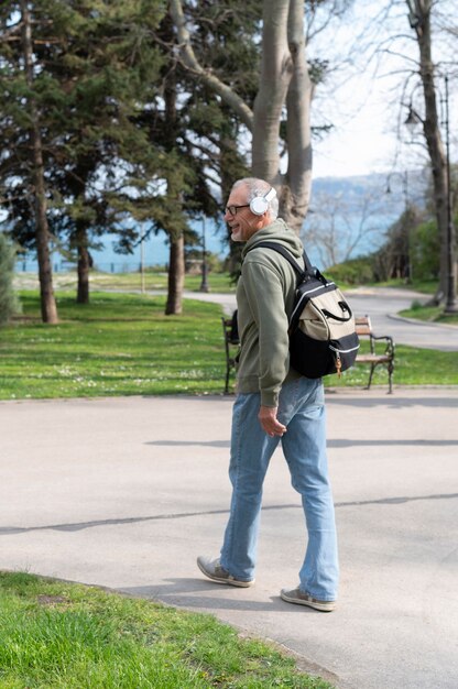 Moderner älterer Mann, der im Park entspannt