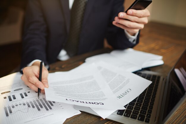 Moderner Geschäftsmann Analyzing Financial Paperwork