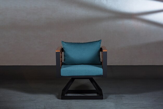 moderner kleiner Stuhl mit einem blauen Kissen darauf in einem Raum