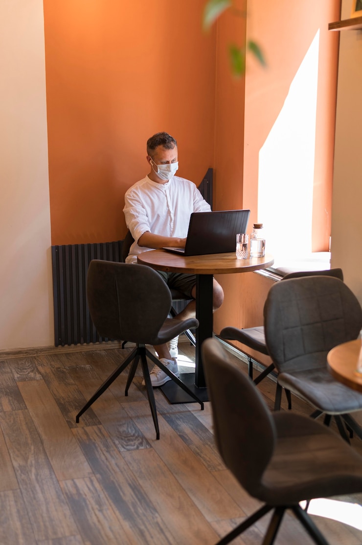 Kostenlose Foto moderner mann, der am laptop im büro arbeitet