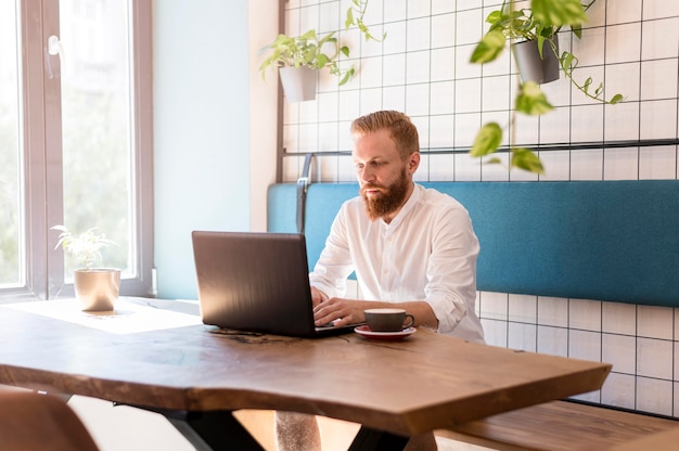 Moderner Mann, der an seinem Laptop arbeitet