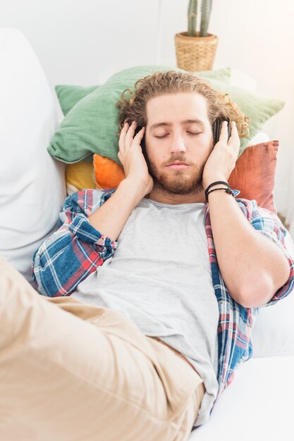 Moderner Mann, der auf Couch sich entspannt