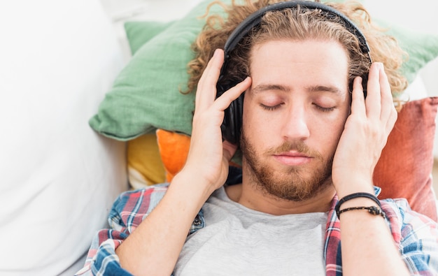 Moderner Mann, der auf Couch sich entspannt