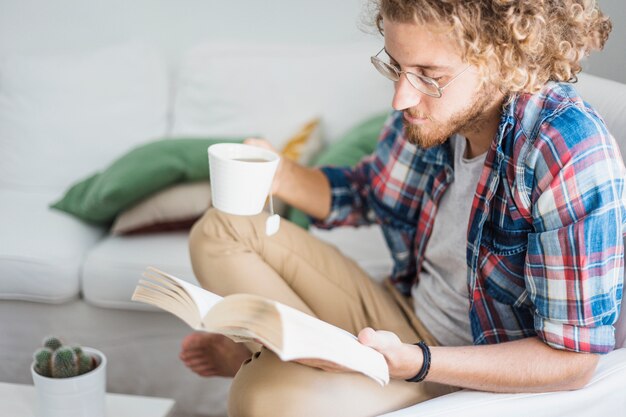 Moderner Mann, der auf Couch sich entspannt