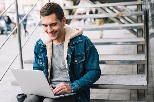 Moderner Mann, der Laptop in der städtischen Umwelt verwendet