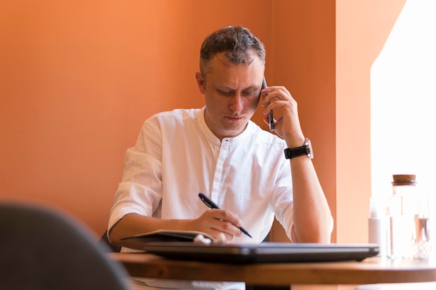 Moderner Mann, der Notizen in seinem Büro macht