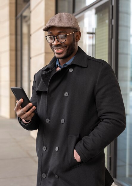 Moderner Mann, der sein Telefon im Freien benutzt