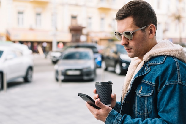 Moderner Mann, der Smartphone in der Stadt verwendet