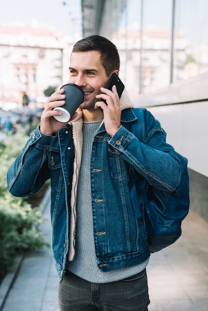 Moderner Mann mit Kaffeetasse in der städtischen Umgebung