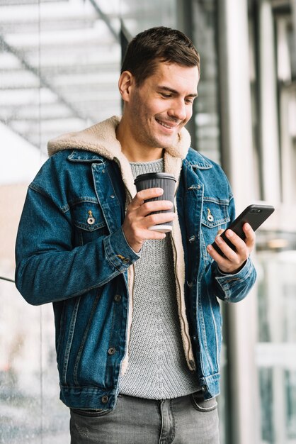 Moderner Mann mit Kaffeetasse in der städtischen Umgebung