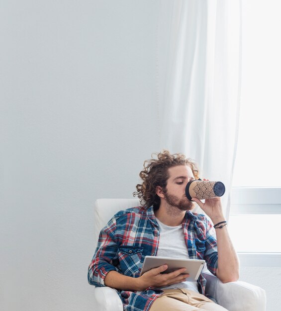 Moderner Mann mit Tisch auf Couch