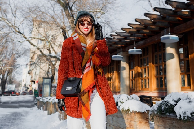 Modische Frau im stilvollen Winteroutfit, die durch die Stadt geht