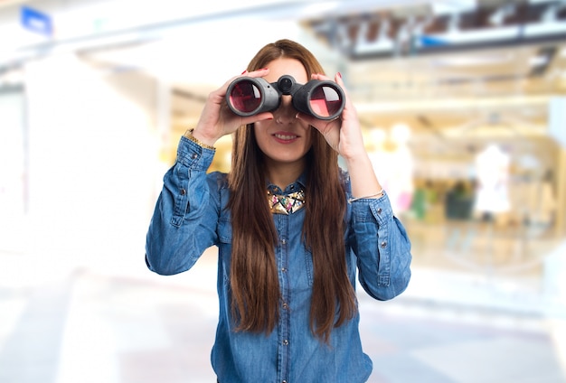 Modische junge Frau mit Fernglas