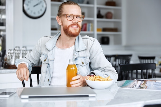 Modischer Hipster-Typ im Jeanshemd und mit stilvoller Brille