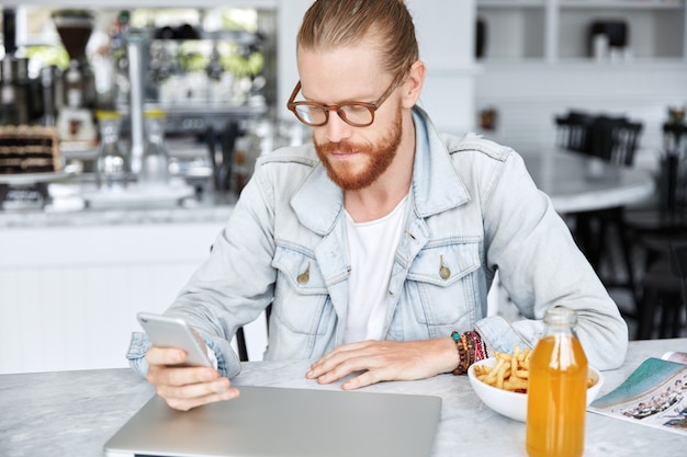 Kostenloses Foto modischer hipster-typ im jeanshemd und mit stilvoller brille