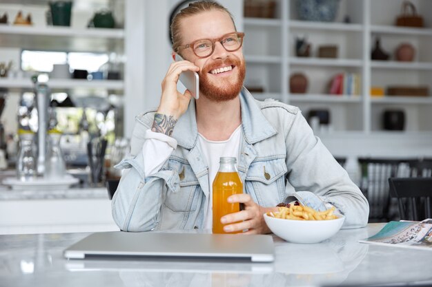 Modischer Hipster-Typ im Jeanshemd und mit stilvoller Brille