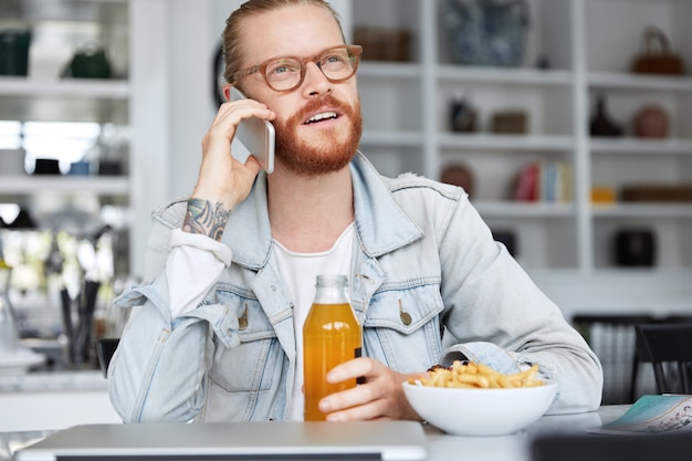 Modischer Hipster-Typ im Jeanshemd und mit stilvoller Brille