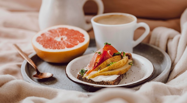 Morgenkaffee mit Sandwich und Grapefruit