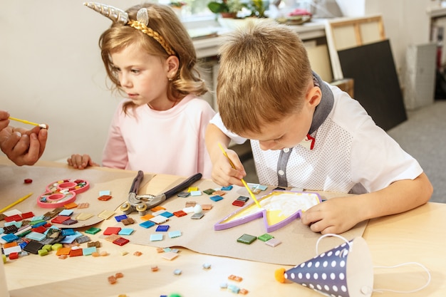 Mosaik-Puzzle-Kunst für Kinder, kreatives Spiel der Kinder. Zwei Schwestern spielen Mosaik