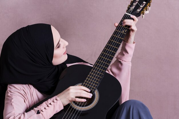 Moslemische Frau, die auf der Gitarre spielt