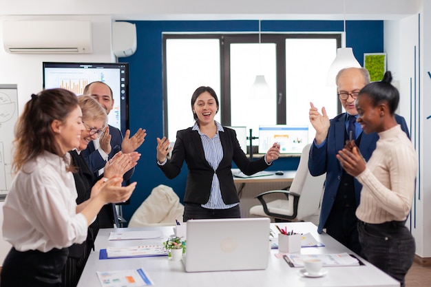 Motivierte, fröhliche, vielfältige Geschäftsteamleute, die beim Firmenmeeting den Erfolg feiern