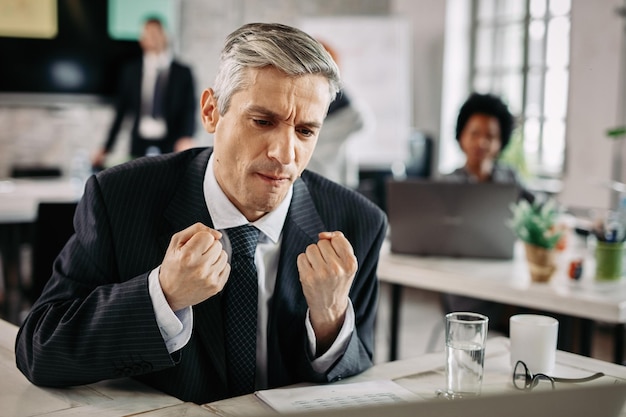 Kostenloses Foto motivierter geschäftsmann fühlt sich nach einer gut gemachten arbeit zufrieden und feiert die leistung bei der arbeit