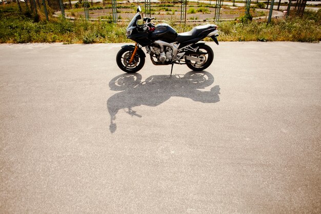 Motorrad auf der Straße mit seinem Schatten