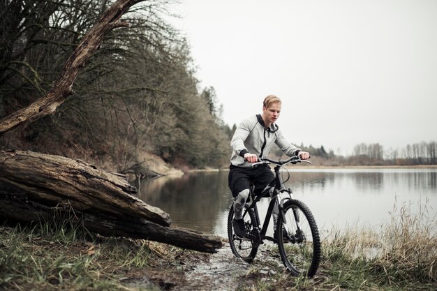 Mountainbiker, der Fahrrad nahe dem See fährt