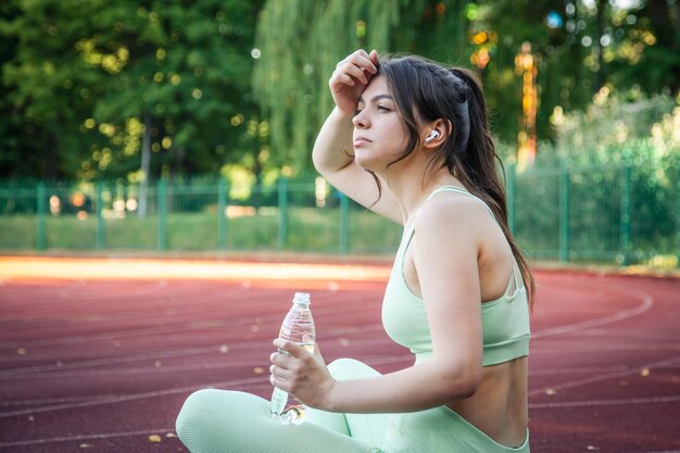 Müde attraktive Frau nach dem Joggen im Stadion