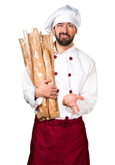 Müder junger Bäcker hält etwas Brot