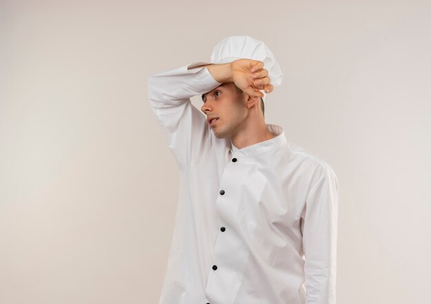 Kostenloses Foto müder junger männlicher koch, der kochuniform trägt, die handgelenk auf seine stirn mit kopienraum setzt
